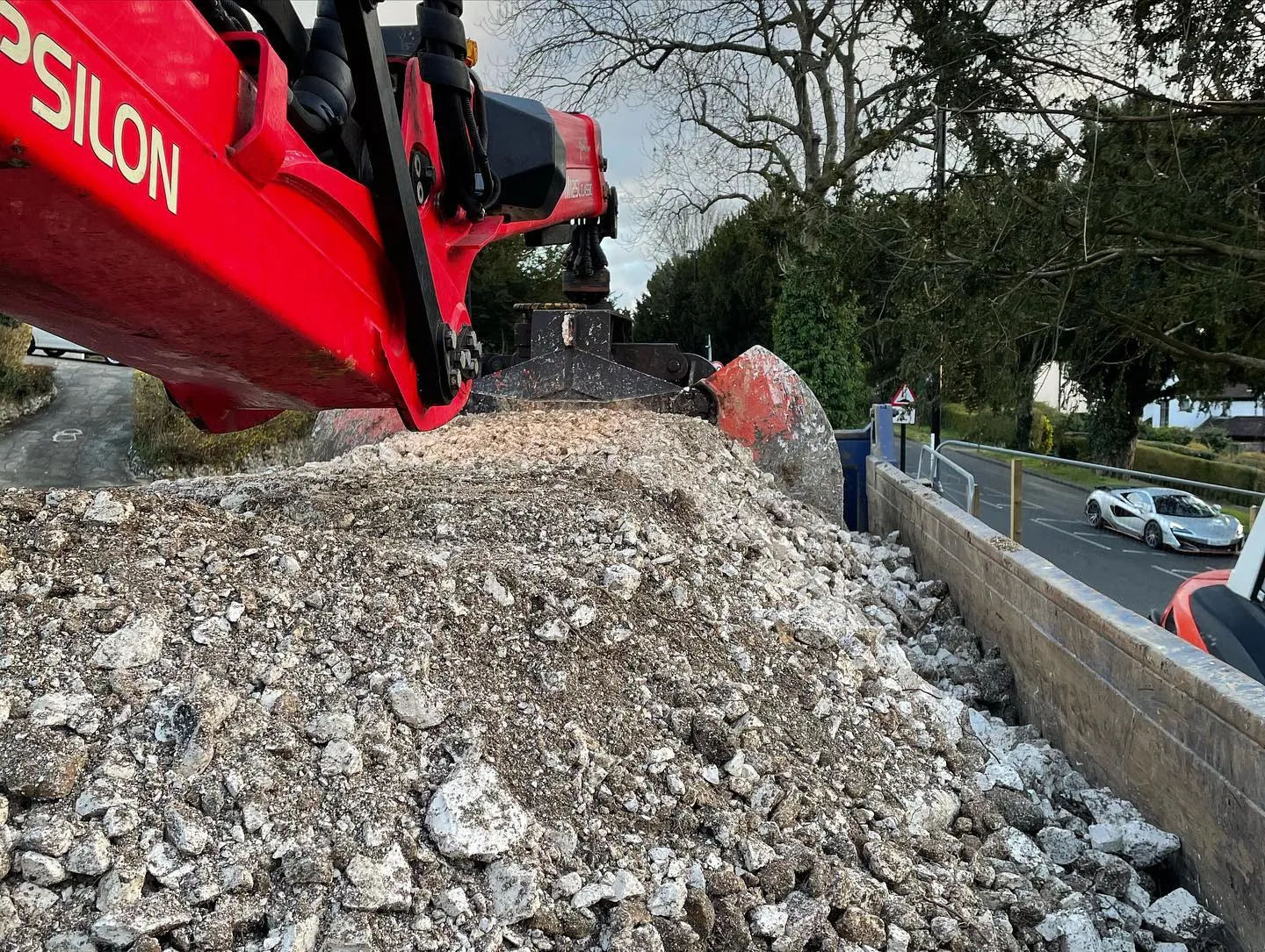 A red bulldozer digging through a pile of rocks.